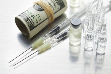 İğne ve ilaç endüstrisi bir sembolü olarak para ile iki şırınga