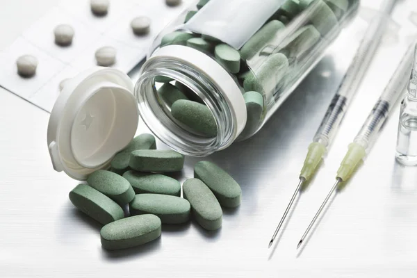 Pilules Vertes Deux Seringues Avec Aiguilles Sur Une Table Grise — Photo