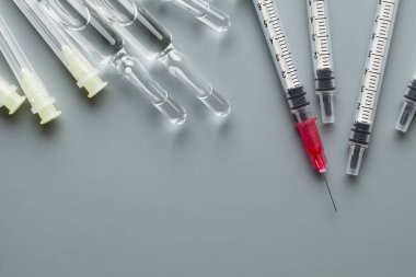 Şırıngalar ve gri arka plan üzerinde ampul