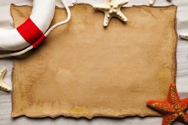 Kağıt sayfası, lifebuoy ve sahilde deniz yıldızı