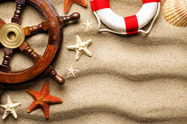 Lifebuoy, geminin direksiyon simidi, çeşitli deniz hayvanı kabuğu denizyıldızı plajda arka plan kum ve