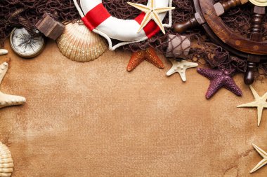 Geminin direksiyon simidi, lifebuoy, pusula, balık ağı ve kabukları Kağıt arka plan üzerinde