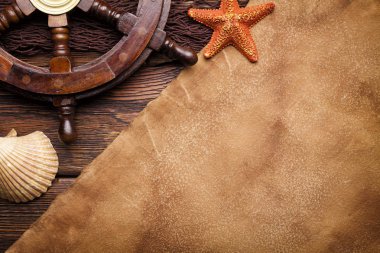 Boş kağıt sayfası, kabukları ve geminin direksiyon simidi üzerinde kahverengi balıkçılık net ve ahşap arka plan