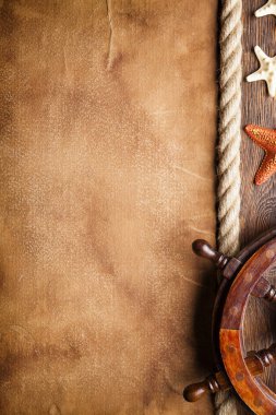 Gemi tekerlek, kabuk, deniz yıldızı ve hawser kağıt ve ahşap arka plan direksiyon'ın