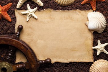 Boş kağıt sayfası, kabukları ve geminin direksiyon simidi üzerinde kahverengi balık ağı 
