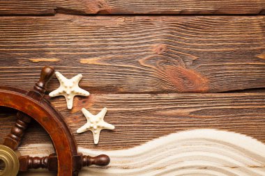 Deniz yıldızı ve geminin direksiyon ahşap arka plan üzerinde