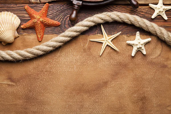 Gemi tekerlek, kabuk, deniz yıldızı ve hawser kağıt ve ahşap arka plan direksiyon'ın