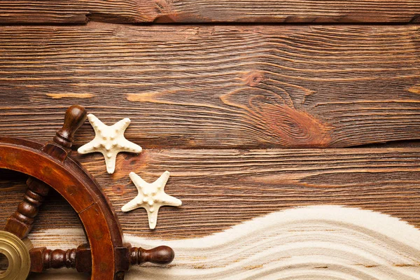Deniz yıldızı ve geminin direksiyon ahşap arka plan üzerinde