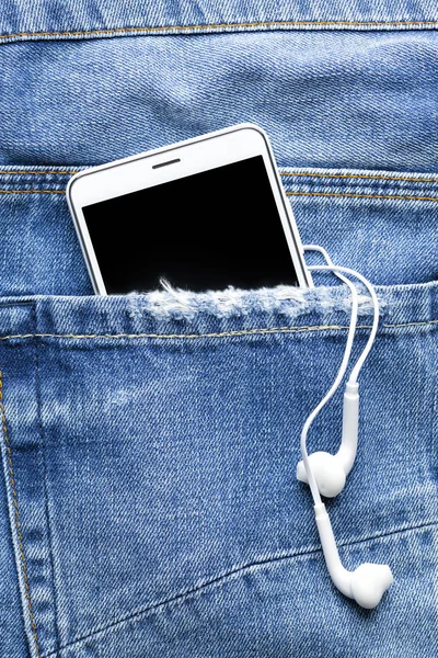 Akıllı telefon ve kulaklık kot pantolon cebinde mobil teknoloji ve müzik bir sembolü olarak