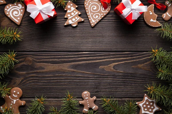 Christmas background - cookies, gifts, spruce tree and decorations on wooden table