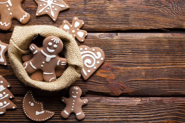 クリスマスのシンボルとして木製のテーブルの上にジュート バッグのジンジャーブレッドのクッキー — ストック写真