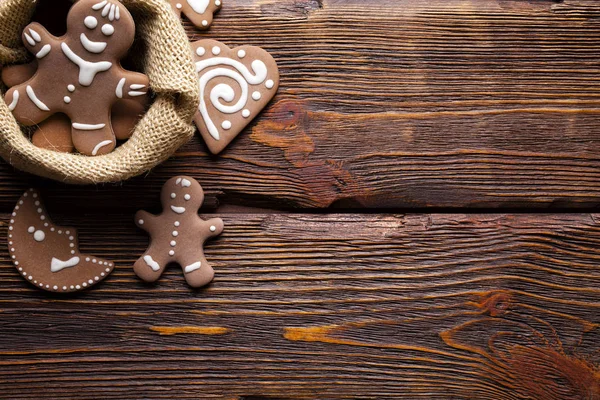 Gingerbread cookies in jute bag on wooden table as Christmas symbols