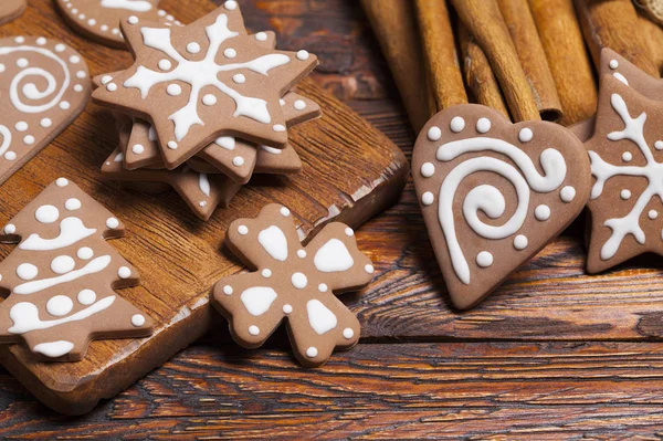 Gingerbread Christmas cookies and cinnamon sticks on wooden table