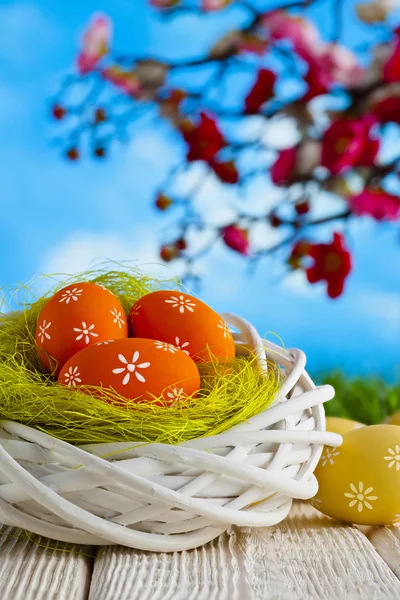Huevos de Pascua en el nido y mesa de madera sobre fondo natural —  Fotos de Stock