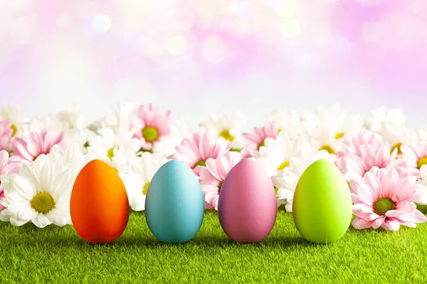 Paskalya yumurtaları çim ve pembe arka plan üzerinde — Stok fotoğraf