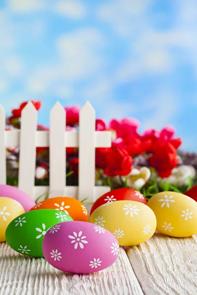 五颜六色的复活节彩蛋和白色栅栏在自然背景 — 图库照片