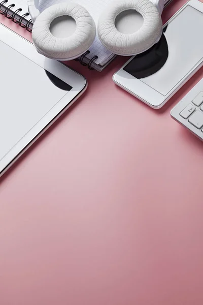 Teléfono móvil, teclado del ordenador, auriculares y portátil en rosa —  Fotos de Stock