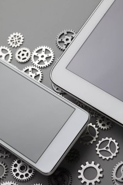 Gri masada cep telefonu ve küçük dişliler