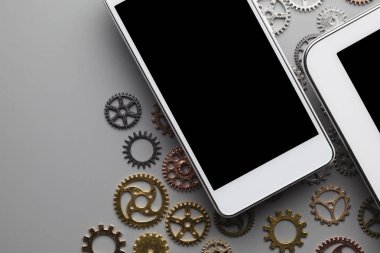 Siyah ekranlı beyaz cep telefonu ve gri sekmeli küçük vitesler.