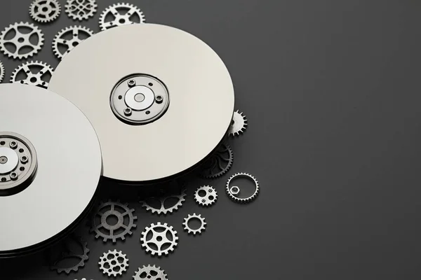 Opened hard disk drive and small gears on gray background — Stock Photo, Image