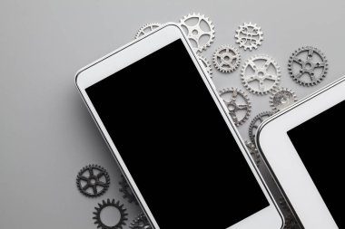 Siyah ekranlı beyaz cep telefonu ve gri sekmeli küçük vitesler.