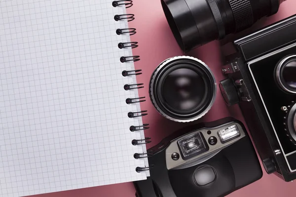 Câmera clássica antiga, lente e notebook com uma página em branco em um pino — Fotografia de Stock