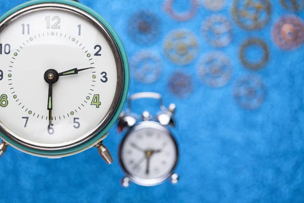 Wecker und Teile der Uhr auf blauem abstrakten Hintergrund — Stockfoto