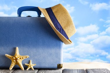 Tatil seyahat konsepti olarak mavi bavul ve yaz şapkası