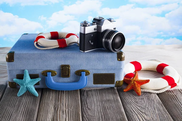 Concetto di borsa per le vacanze estive valigia, macchina fotografica e salvagente — Foto Stock