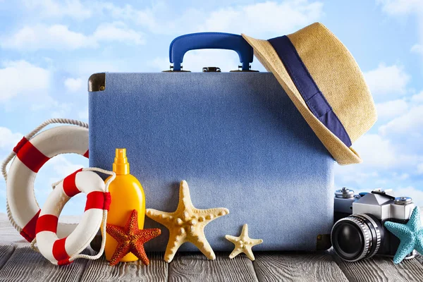 Concepto de bolsa de viaje - maleta, sombrero de verano, aceite de bronceado y foto —  Fotos de Stock