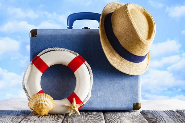 Valigia da vacanza, cappello estivo, salvagente e conchiglie sulla schiena della spiaggia — Foto Stock