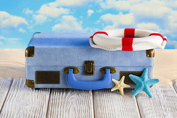 Beyaz ahşap masa ve plaj arka planda yaz tatil çantası — Stok fotoğraf