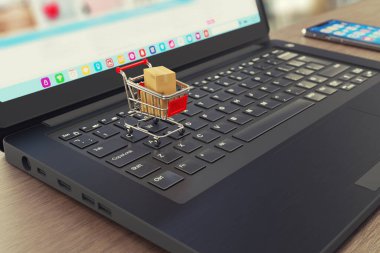 Çevrimiçi alışveriş ve teslimat sembolleri - alışveriş arabası, karton nakliye kutuları, dizüstü bilgisayar ve akıllı telefon - internet mağazası - 3D illüstrasyon