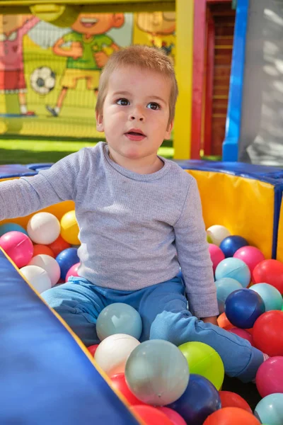 Petit garçon jouant avec des boules colorées — Photo