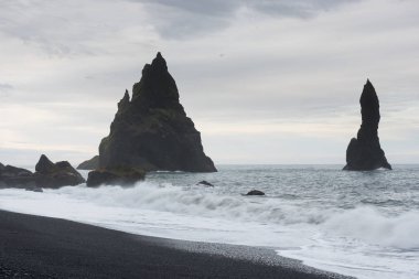 Ünlü Reynisdrangar kaya oluşumları siyah Reynisfjara Plajı'nda. Vik, Güney İzlanda yakınındaki Atlantik Okyanusu kıyısında.