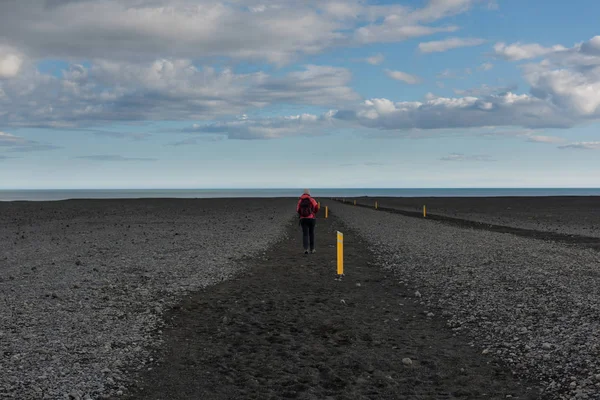 徒步旅行妇女在冰岛自然风景与黑沙路 徒步旅行者可以欣赏到冰岛著名的黑色沙滩 — 图库照片