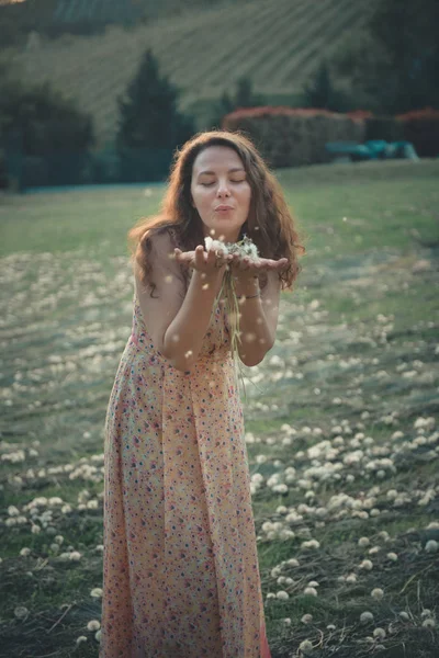 夏の公園でタンポポを吹く美少女 緑美しい自然の草 — ストック写真