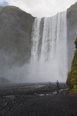 İnsanlar tarafından Skogafoss şelale İzlanda Altın çember üzerinde. Ziyaret ünlü turistik mekanlara ve simge yapılar İzlanda doğa manzara çift