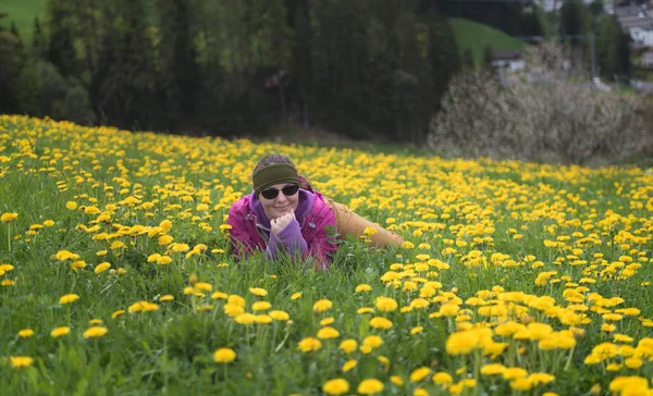 草原の花で覆われ ハイキングの後の残りの部分を持っていることを置くアクティブな若い女性 — ストック写真