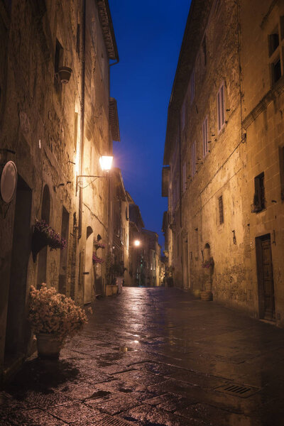 Old European city Pienza street at rainy night, Tuscany, Italy