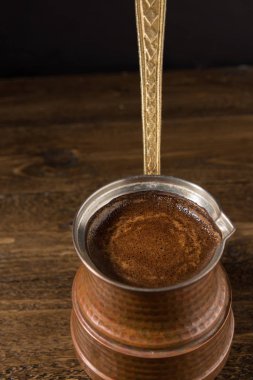 Ahşap masa üzerinde Türk bakır tencerede sıcak kahve