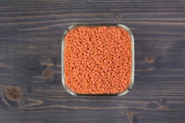 Cam plaka ahşap masa arka plan üzerinde kırmızı mercimek