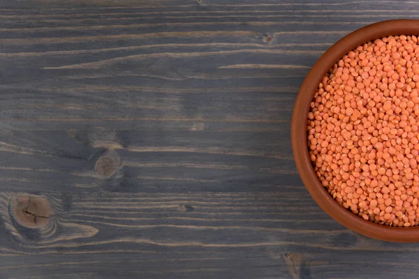 Kil plaka ahşap masa arka plan üzerinde kırmızı mercimek