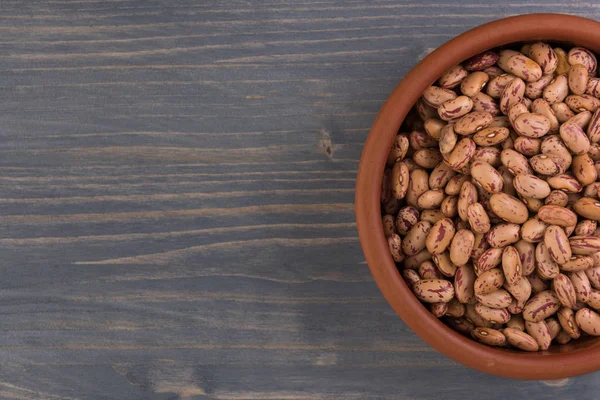 Bir tabak fasulye ahşap masa arka plan üzerinde