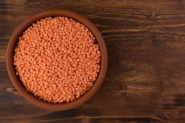 Kil plaka ahşap masa arka plan üzerinde kırmızı mercimek