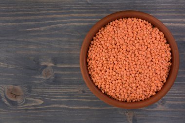 Kil plaka ahşap masa arka plan üzerinde kırmızı mercimek