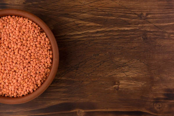 Kil plaka ahşap masa arka plan üzerinde kırmızı mercimek