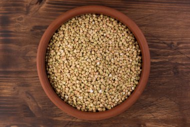 Kil kase ahşap arka plan üzerinde doğal taze yeşil buğday. Üstten görünüm