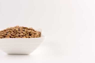 Bir kasede beyaz arka plan üzerinde izole sarı mercimek 