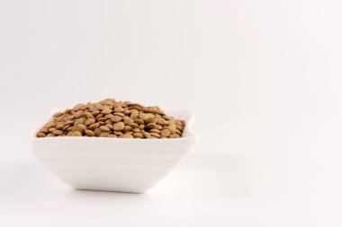 Bir kasede beyaz arka plan üzerinde izole sarı mercimek 